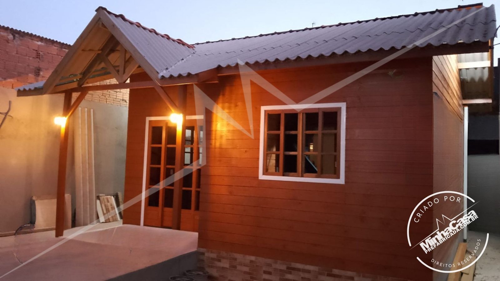 POP 1.3 de 34,35m² — Fachada principal real construída à noite com iluminação externa POP 1.3 de 34,35m² pré-fabricado em madeira pinus autoclave — fachada principal real construída à noite com iluminação externa