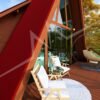 Chalé A-Frame 10 de 46,85m² pré-fabricado em madeira pinus autoclave — fachada principal com deck em visão próxima e lateral direita