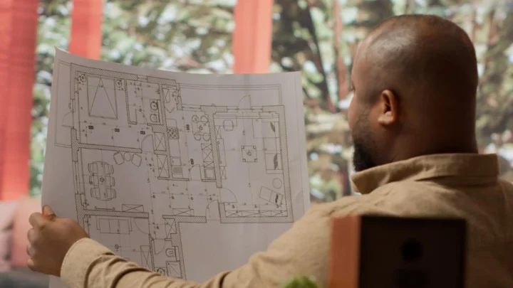 Um homem observa o projeto casa de madeira