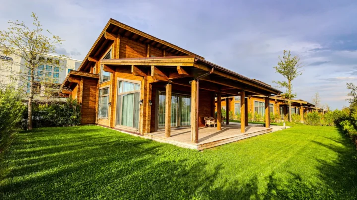 Casa de madeira tratada com varanda em paisagem verde